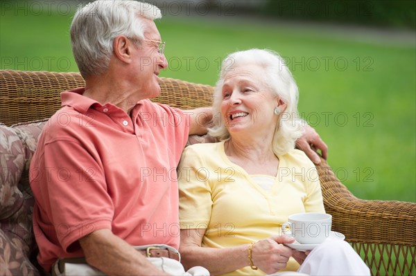 Senior couple relaxing on outdoor sofa.