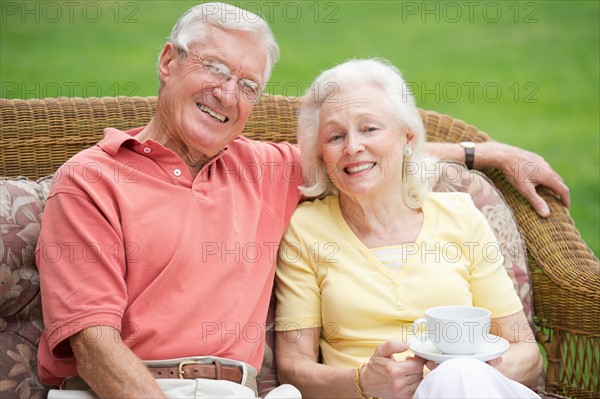 Senior couple relaxing on outdoor sofa.