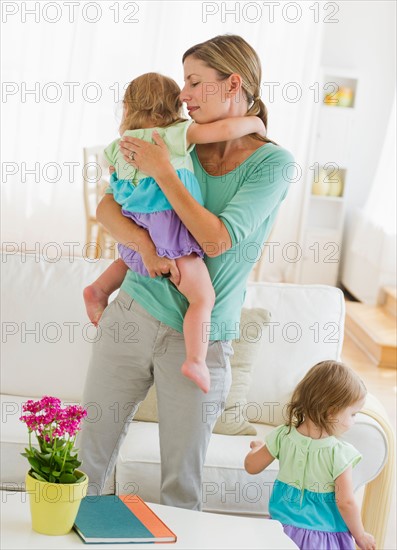 Mother with daughters (2-3) in living room.