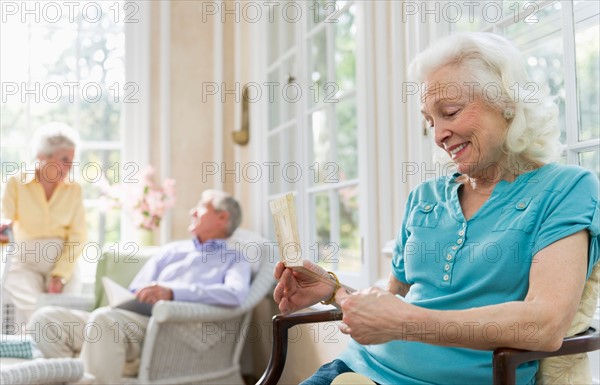 Senior woman reading greeting card.