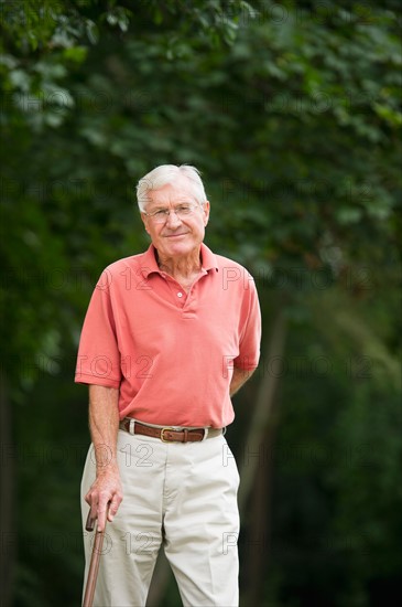 Senior man standing in park.