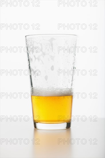 Studio shot of half full beer glass.