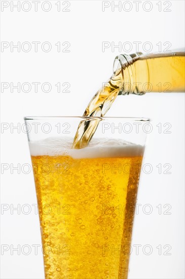 Beer pouring into glass, studio shot.