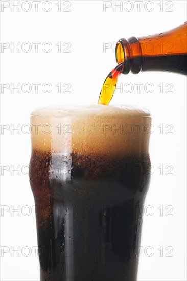 Ale pouring into glass, studio shot.