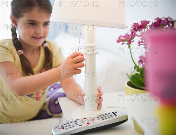 Girl ( 6-7) turning off lamp. Photo: Jamie Grill