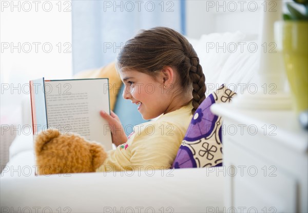 Girl ( 6-7) reading onSofa. Photo: Jamie Grill