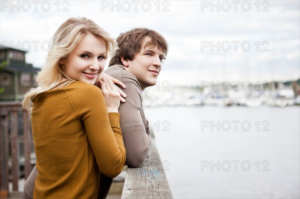 USA, Washington, Seattle, Young couple on pier, woman looking at camera. Photo: Take A Pix Media