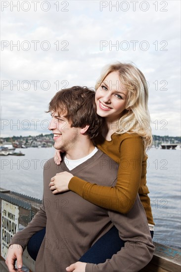 USA, Washington, Seattle, Young couple on pier, woman looking at camera. Photo : Take A Pix Media