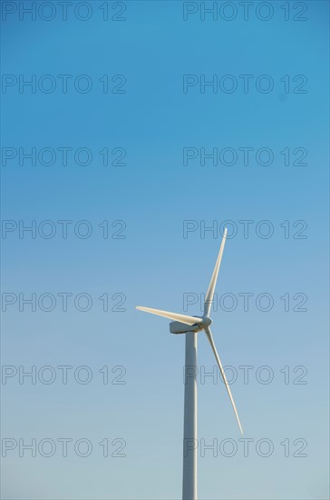 Turkey, Cesme, wind turbine against blue sky. Photo : Tetra Images