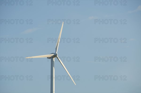 Turkey, Izmir, wind turbine against blue sky. Photo: Tetra Images