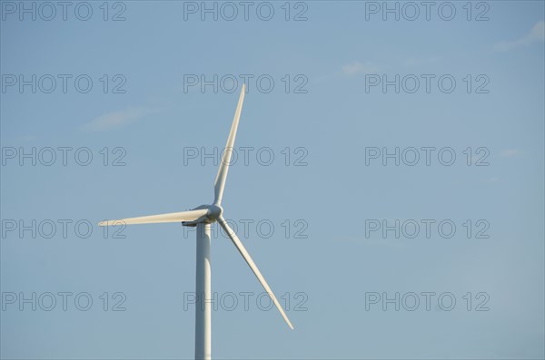 Turkey, Izmir, wind turbine against blue sky. Photo : Tetra Images