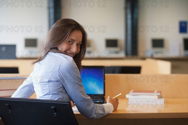 Portrait of female student studying in library. Photo : Jan Scherders