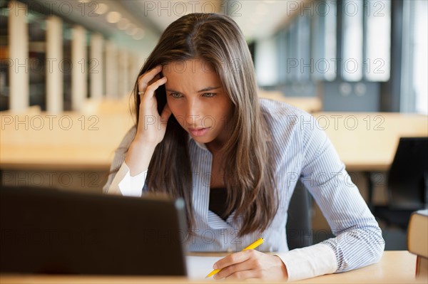 Female student studying in library. Photo : Jan Scherders