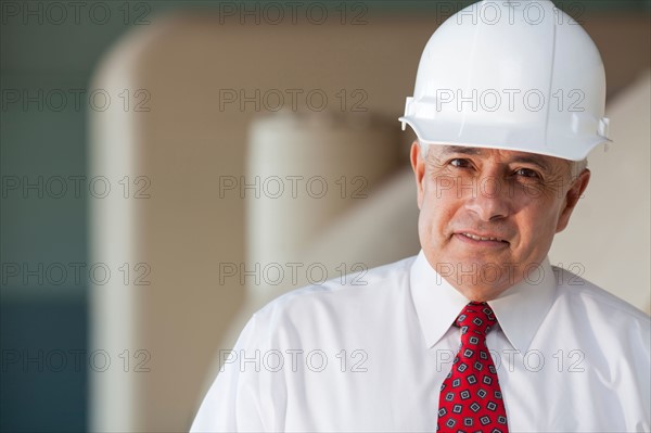 Portrait of senior man wearing tie and hardhat. Photo: db2stock