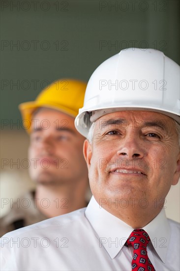 Portrait of senior man wearing tie and hardhat. Photo: db2stock