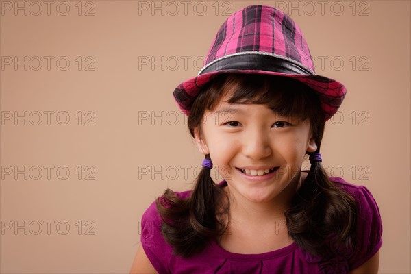 Studio portrait of girl (10-11) wearing hat. Photo : Rob Lewine