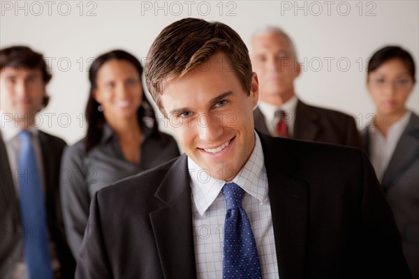 Studio shot of business people, focus on young business man. Photo : Rob Lewine