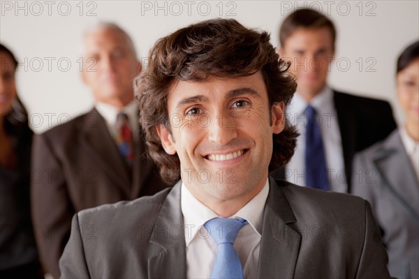 Studio shot of business people, focus on mid adult business man. Photo : Rob Lewine