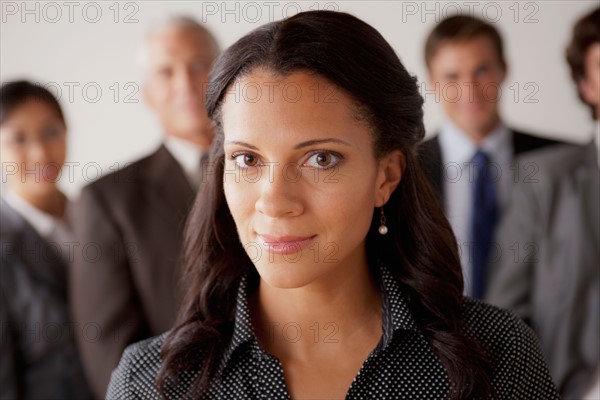 Studio shot of business people, focus on mid adult business woman. Photo : Rob Lewine