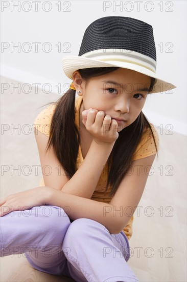 Studio portrait of girl (8-9) wearing hat. Photo : Rob Lewine