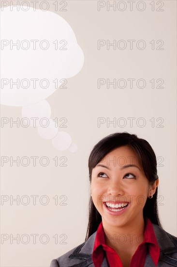 Studio portrait of businesswoman with thought bubble. Photo: Rob Lewine