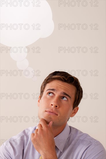 Studio portrait of businessman with thought bubble. Photo: Rob Lewine