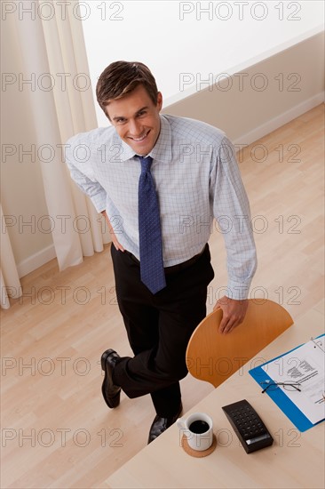 Portrait of young smiling businessman in office. Photo: Rob Lewine