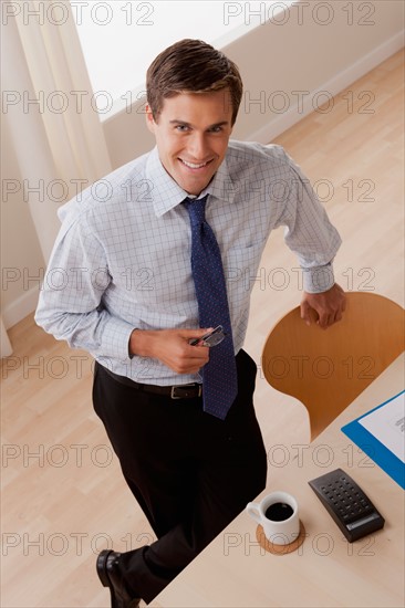 Portrait of young smiling businessman in office. Photo: Rob Lewine