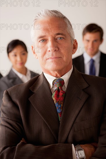 Studio shot of business people, focus on senior business man. Photo: Rob Lewine