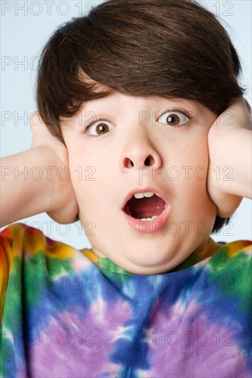 Studio portrait of boy (10-11) with head in hands. Photo : Rob Lewine