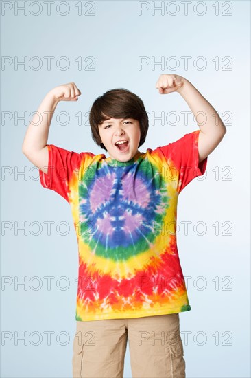 Studio portrait of boy (10-11) flexing muscles. Photo : Rob Lewine