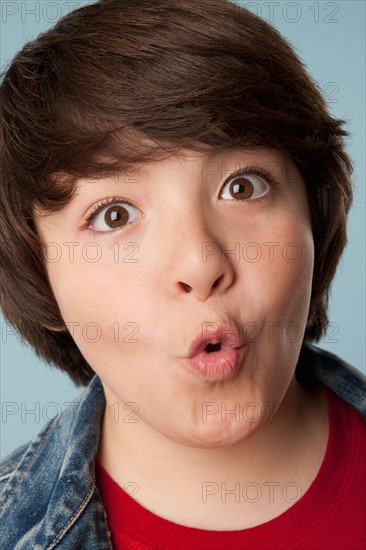 Studio portrait of boy (10-11) making a face. Photo: Rob Lewine