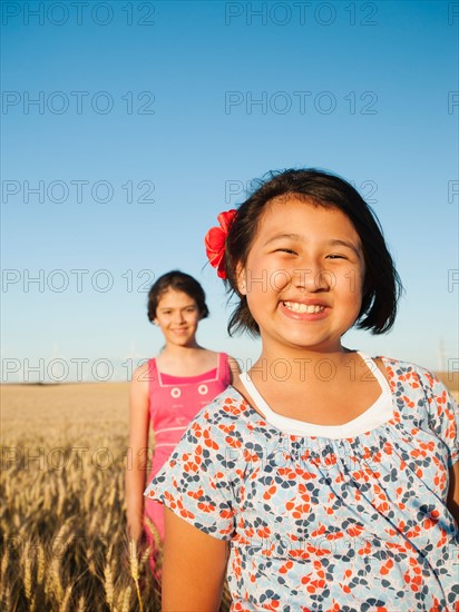 Girls (10-11, 12-13) standing in whet field.