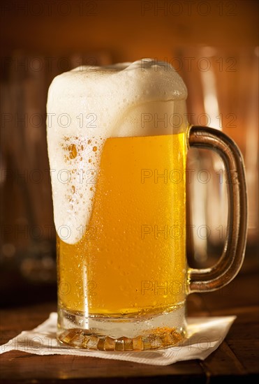 Lager in beer glass on bar counter.