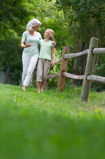 Girl (10-11) and grandmother walking together.