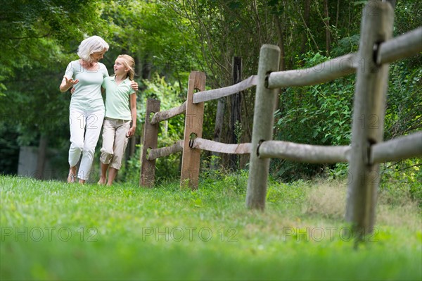 Girl (10-11) and grandmother walking together.