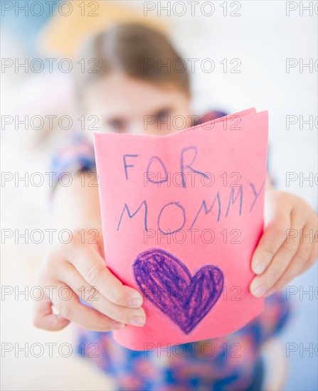 Girl ( 6-7) showing greeting card for mother's day. Photo : Jamie Grill