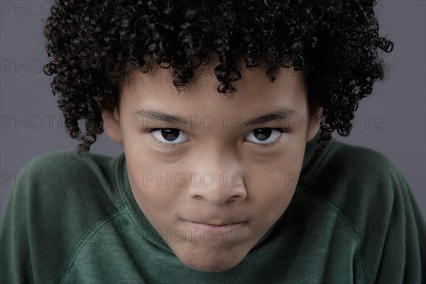 Portrait of boy (8-9) looking angry, studio shot. Photo : Rob Lewine