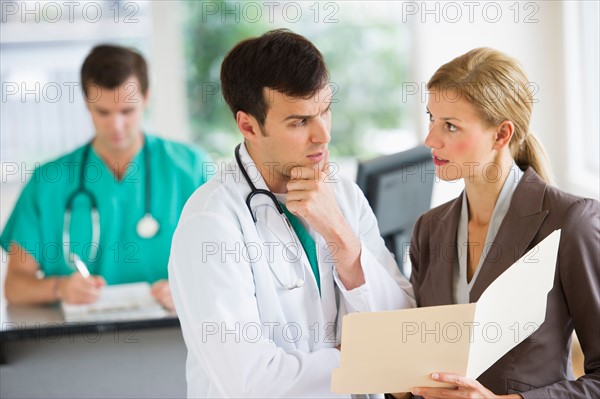 Doctor and businesswoman discussing files.