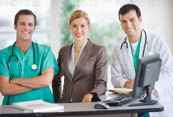 Portrait of doctors and businesswoman at nurse's station.