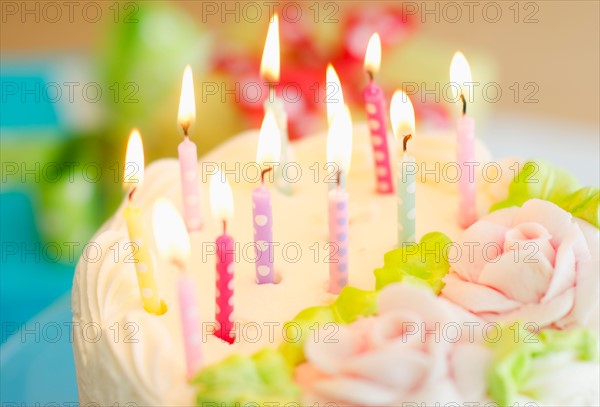 Illuminated candles on cake.