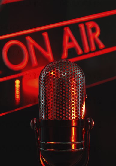 Vintage microphone and red on air neon, studio shot.