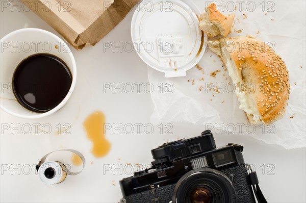 Breakfast and camera on table, studio shot.