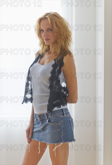 Portrait of woman standing by window.