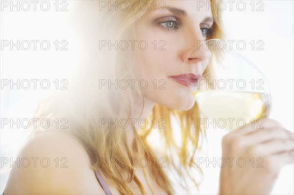 Young woman tasting wine, studio shot.