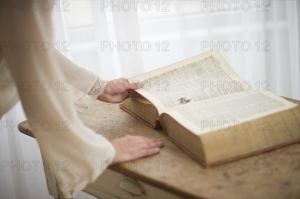 Woman reading antique book.