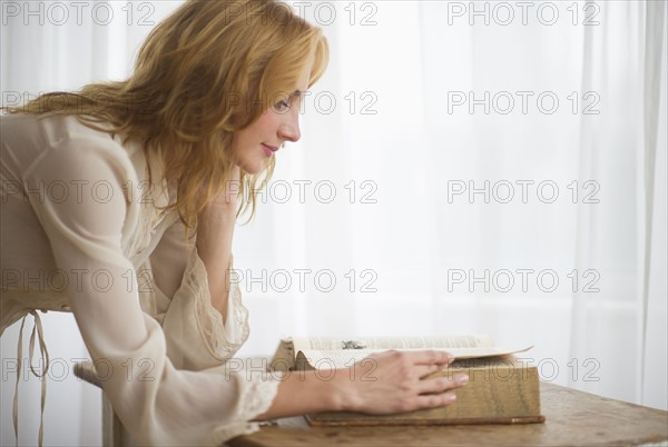 Woman reading antique book.