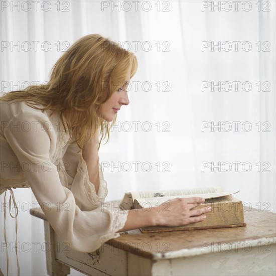 Woman reading antique book.