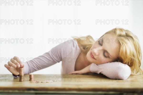 Woman stacking coins, studio shot.