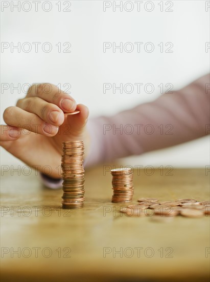 Woman's hand stacking coins, studio shot.